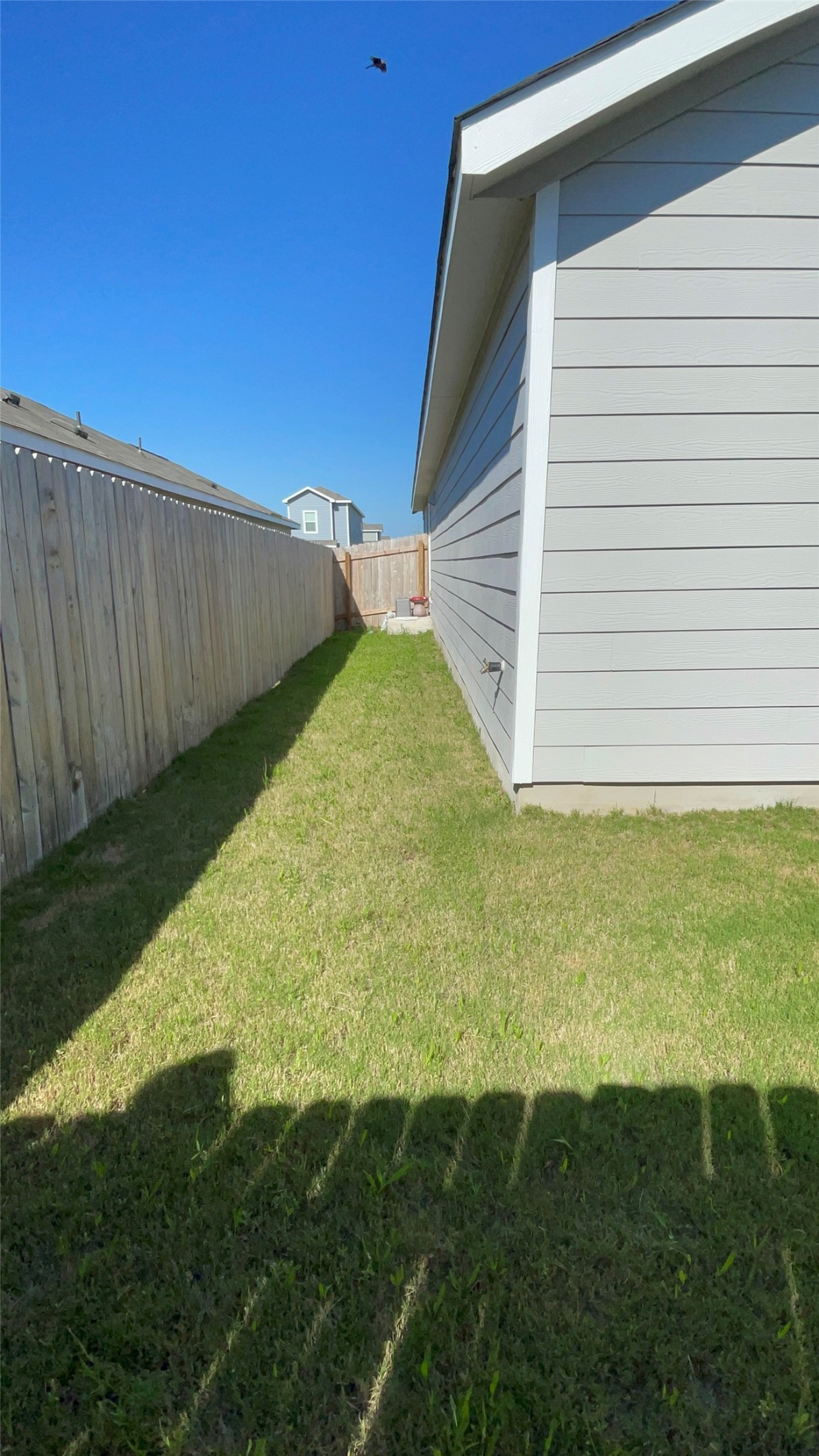 212 Marty Allen Loop Jarrell, TX 76537 - Photo 6 of 13 Side yard featuring a wood privacy fence, green lawn, and light gray horizontal siding