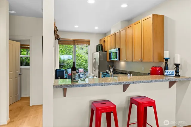 a kitchen with kitchen island granite countertop a sink and cabinets