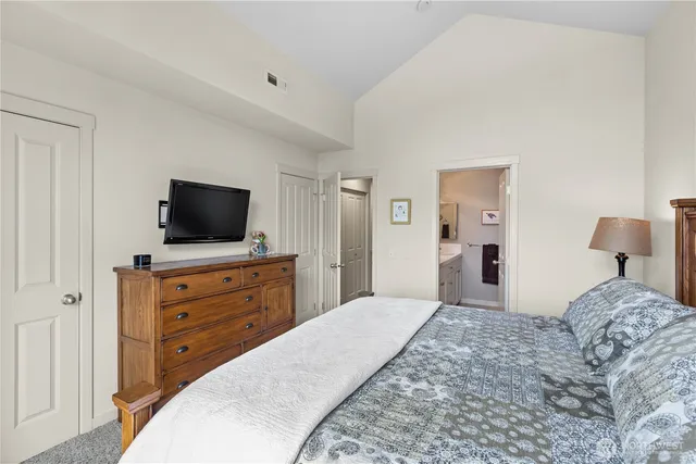 a bedroom with a bed and flat screen tv