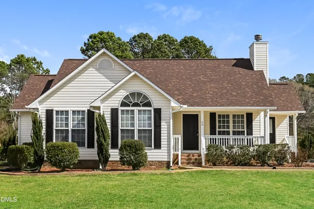 a front view of a house with a yard and potted plants