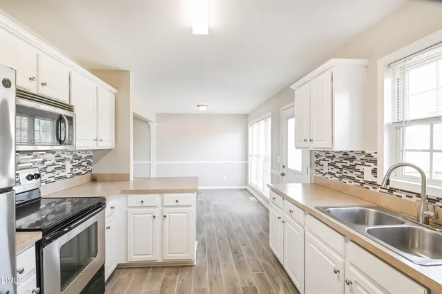 a kitchen with a sink stove top oven and refrigerator