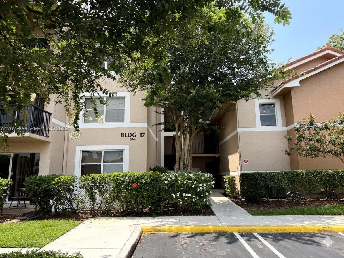 8761 Wiles Road, Unit 206 Coral Springs, FL 33067 - Photo 26 of 26 a front view of a house with lots of trees