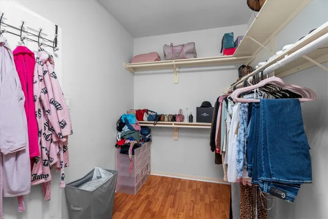 a view of walk in closet with clothes and shoes