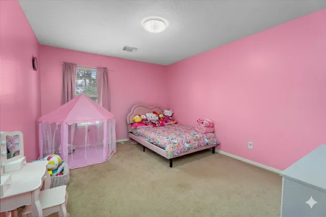 a bedroom with pink walls and pink rug