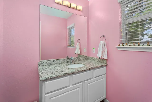 a bathroom with a granite countertop sink and a mirror
