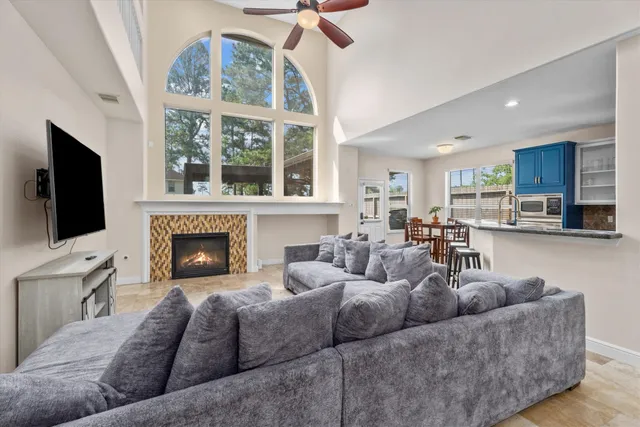 a living room with furniture a flat screen tv and a fireplace