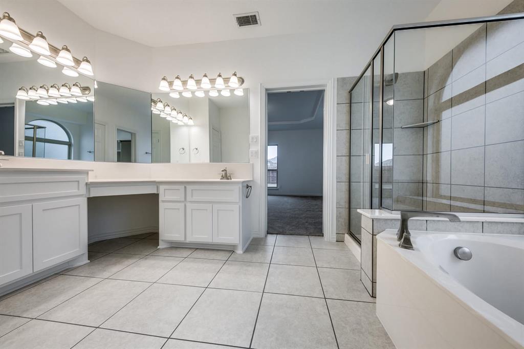 104 Sweetleaf Drive Red Oak, TX 75154 - Photo 17 of 36 The bathroom features a dual vanity with white cabinetry, a built-in makeup vanity, and large mirrors