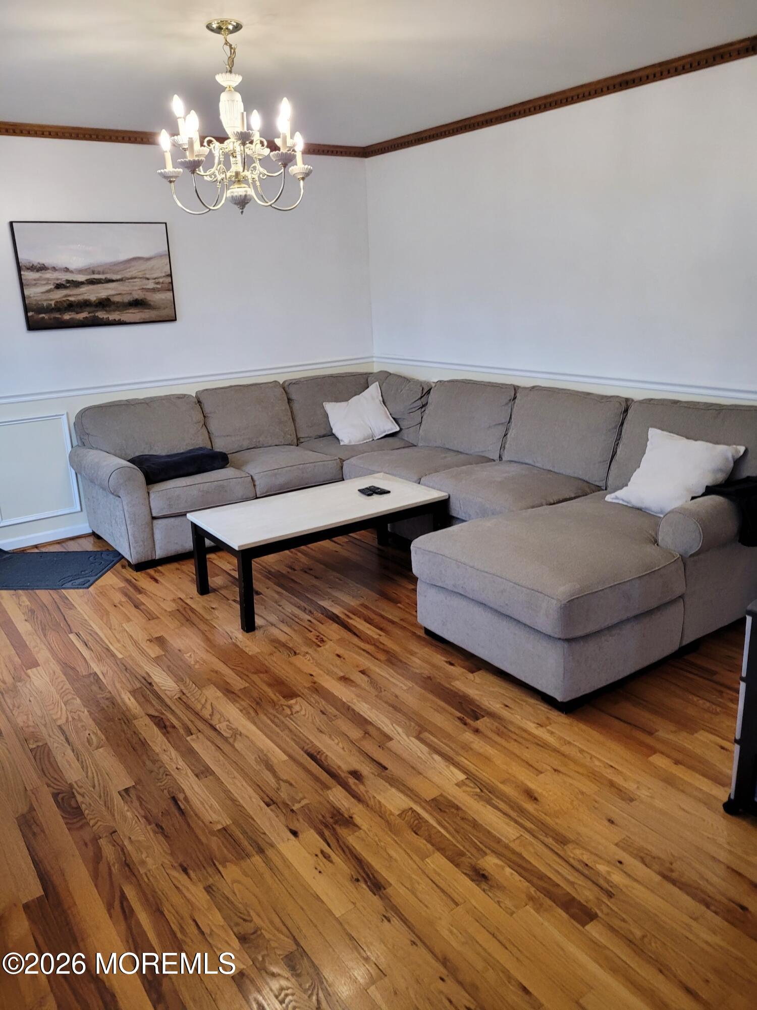 5 Peach Tree Road Oakhurst, NJ 07755 - Photo 2 of 6 a living room with furniture and a chandelier