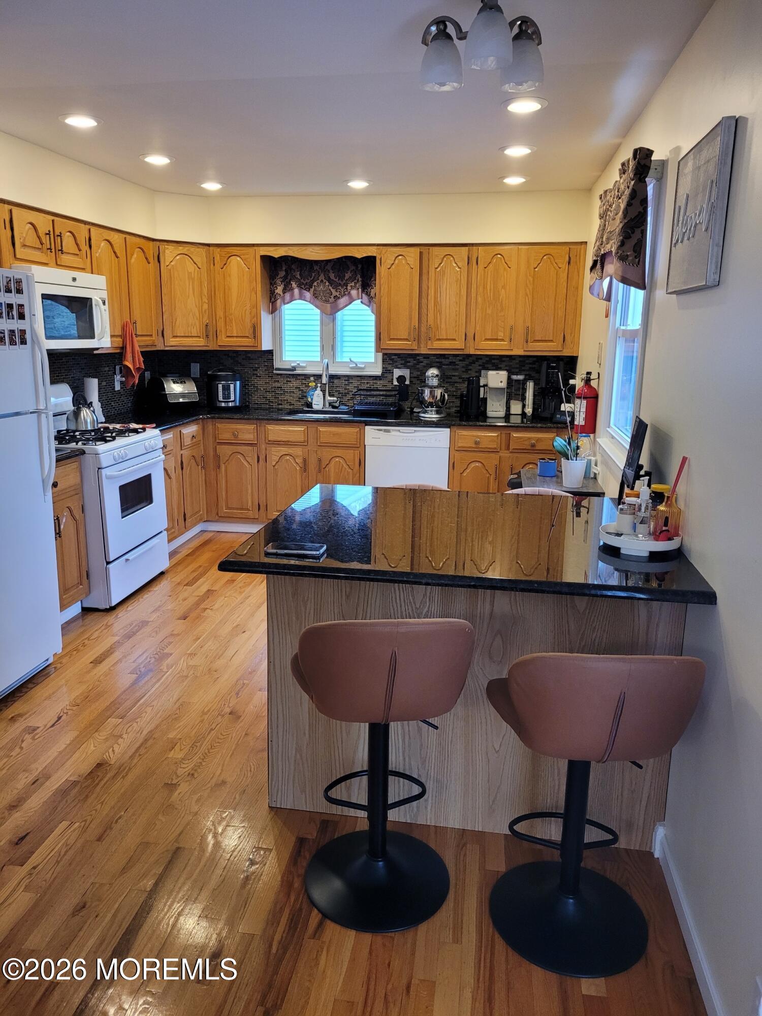 5 Peach Tree Road Oakhurst, NJ 07755 - Photo 3 of 6 a kitchen with stainless steel appliances granite countertop a refrigerator a sink a stove a microwave and wooden cabinets