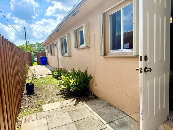 a potted plant sitting in front of a house with a yard