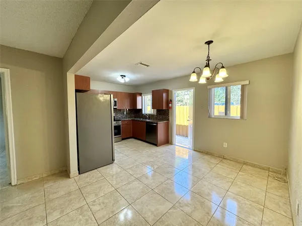 a view of a kitchen with kitchen island stainless steel appliances refrigerator sink and cabinets