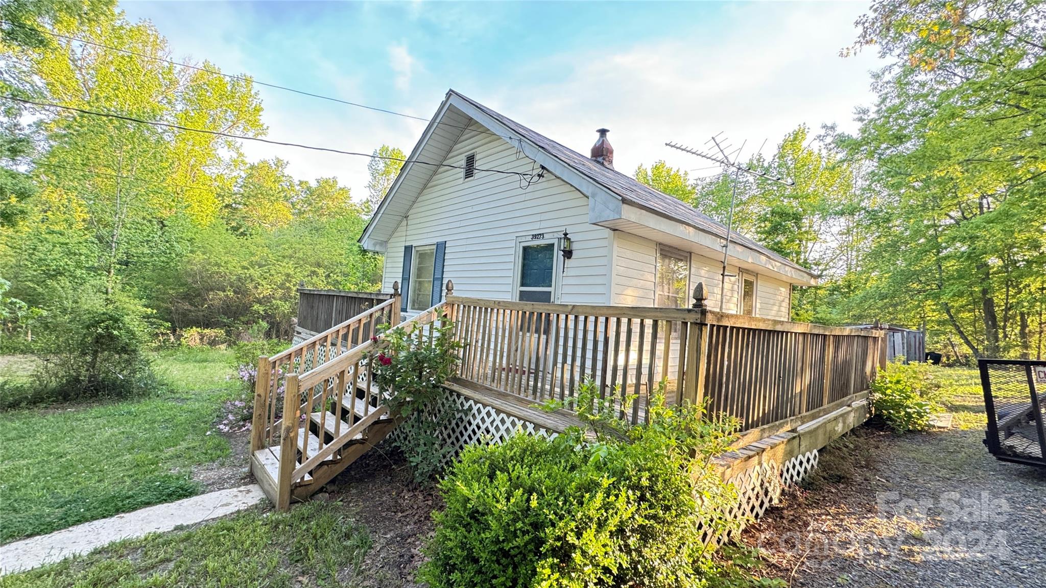 a view of a house with a small yard and wooden fence
