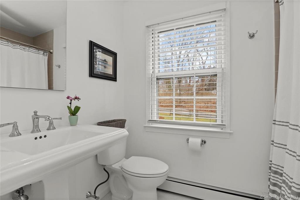 183 Frogtown Road New Canaan, CT 06840 - Photo 19 of 37 a bathroom with a sink a toilet and a mirror