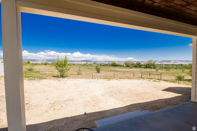 3322 250 S Street Vernal, UT 84078 - Photo 33 of 37 Covered patio area with concrete flooring, framed by light-colored structural columns and a dark wood-finish ceiling
