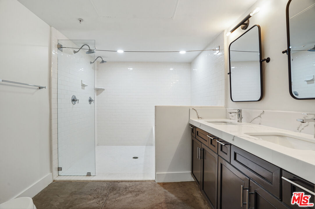 4141 Glencoe Avenue, Unit 211 Marina del Rey, CA 90292 - Photo 15 of 49 a bathroom with a granite countertop sink a shower and a mirror