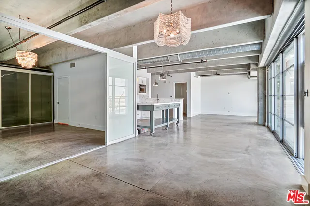 a view of a hallway with wooden floor and chandelier