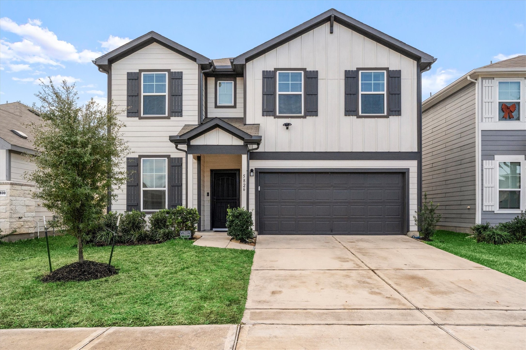 a front view of a house with a yard and trees