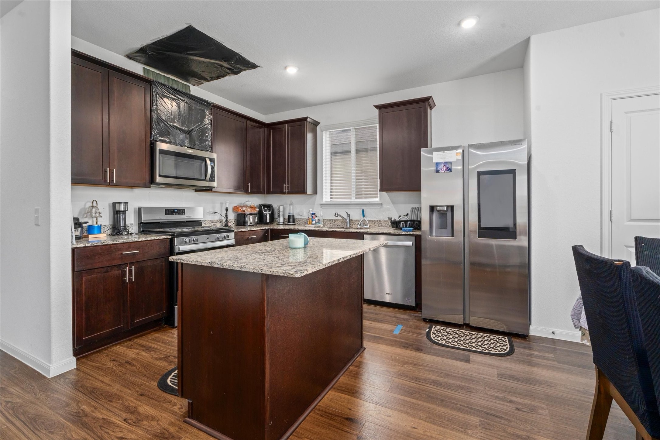 5826 Finely Run St Spring Spring, TX 77373 - Photo 14 of 38 a kitchen with stainless steel appliances granite countertop a refrigerator a sink a stove a microwave and wooden cabinets