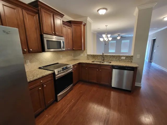a kitchen with stainless steel appliances granite countertop a stove a sink and a refrigerator