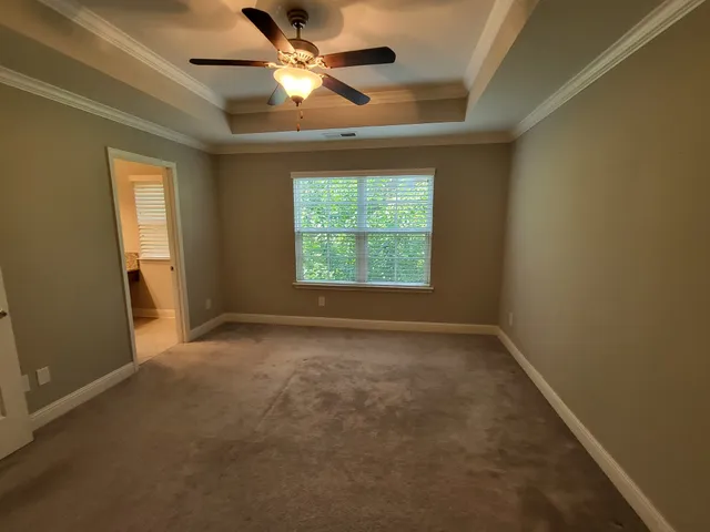an empty room with a window and a fan