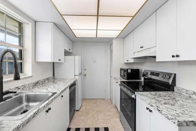 a kitchen with stainless steel appliances granite countertop a sink stove and refrigerator