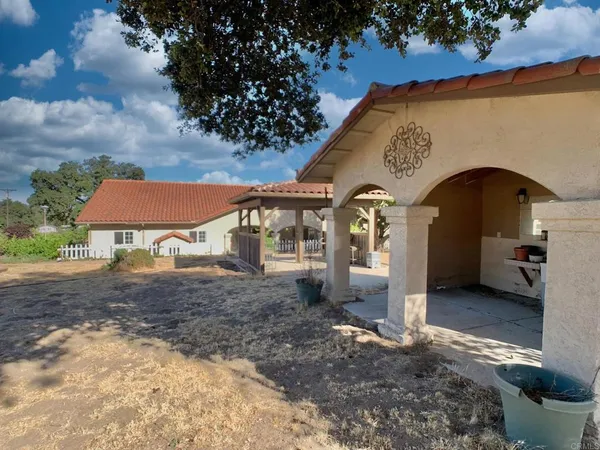 a backyard of a house with table and chairs and wooden floor