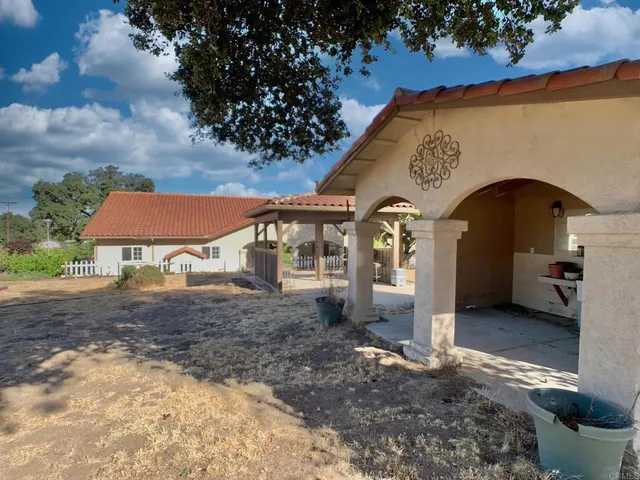 a backyard of a house with table and chairs and wooden floor