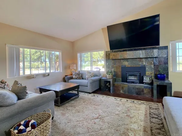 a dining room with wooden floor a chandelier a wooden table and chairs