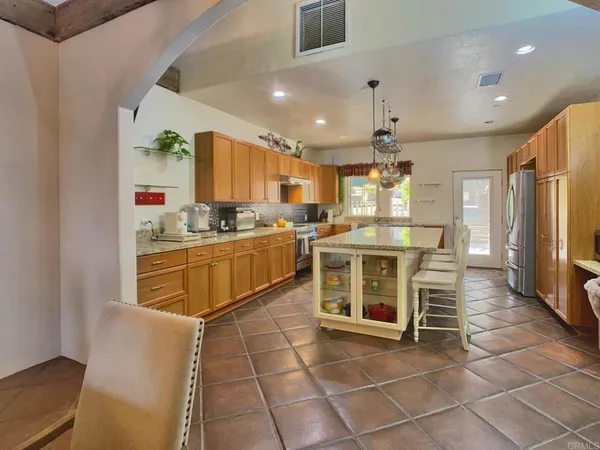 a kitchen with cabinets appliances and a dining table