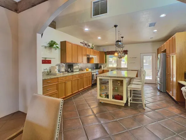 a kitchen with cabinets appliances and a dining table