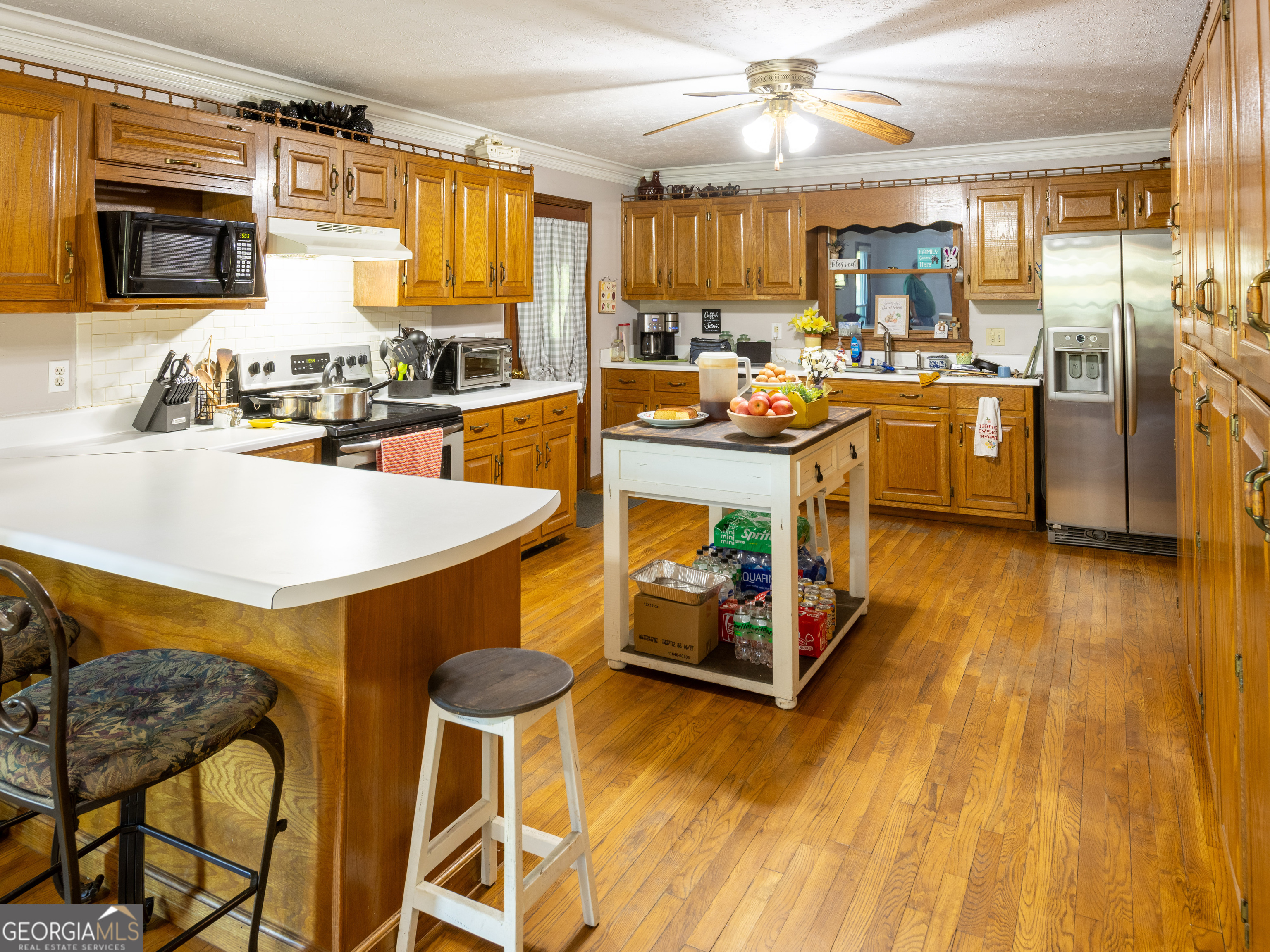 201 Little New York Road Carrollton, GA 30116 - Photo 29 of 29 a kitchen with stainless steel appliances kitchen island granite countertop a table chairs sink and cabinets