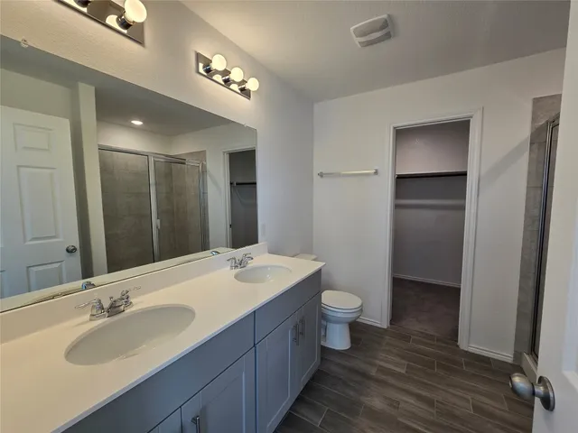 a bathroom with a double vanity sink toilet and a mirror