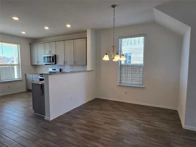 a kitchen with stainless steel appliances granite countertop a stove a sink and a wooden floors
