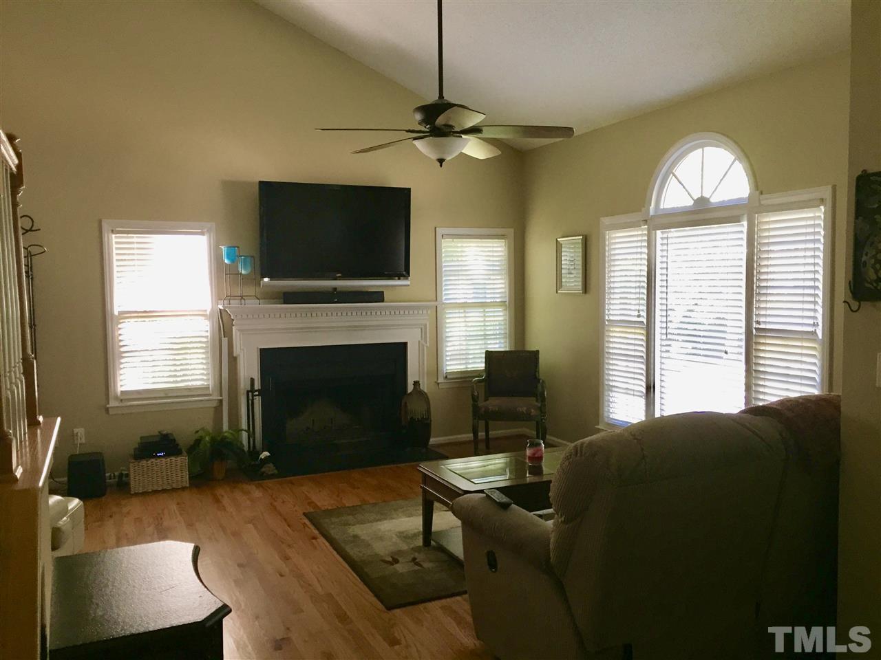11917 Eagle Bluff Circle Raleigh, NC 27613 - Photo 6 of 25 a living room with furniture a flat screen tv and a fireplace
