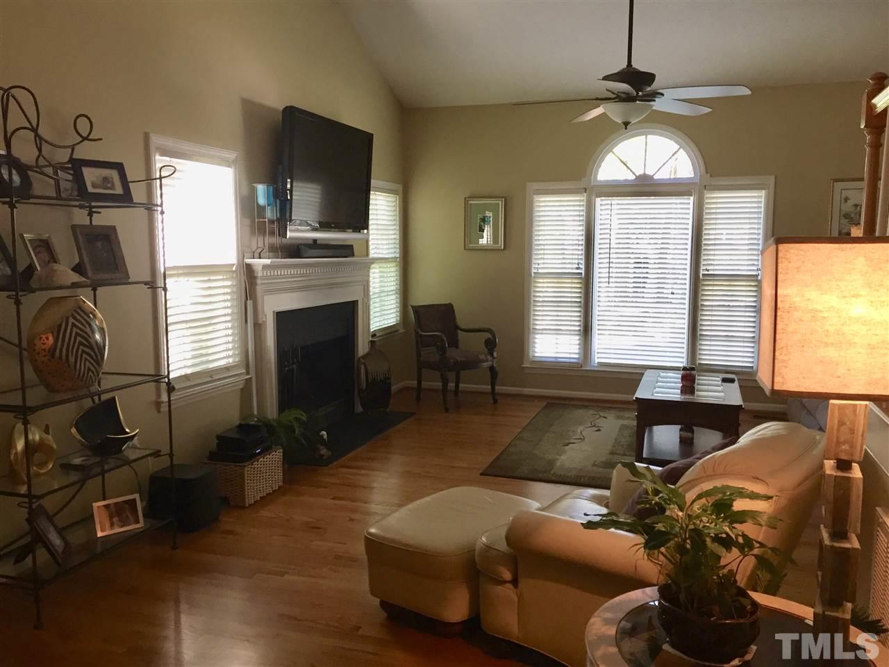 11917 Eagle Bluff Circle Raleigh, NC 27613 - Photo 8 of 25 a living room with furniture a fireplace and a flat screen tv