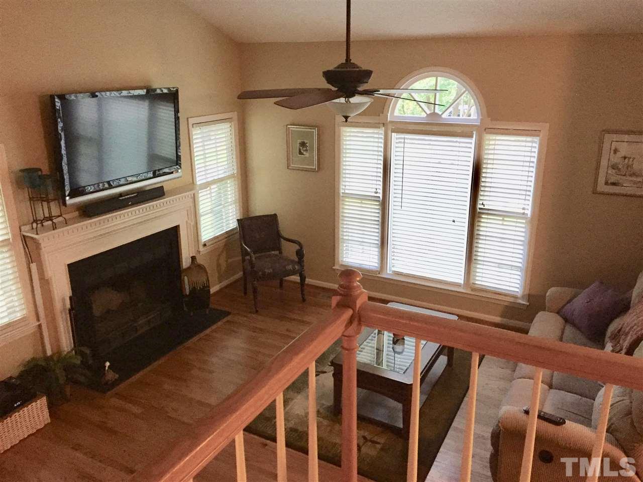 11917 Eagle Bluff Circle Raleigh, NC 27613 - Photo 9 of 25 a living room with furniture a flat screen tv and a fireplace