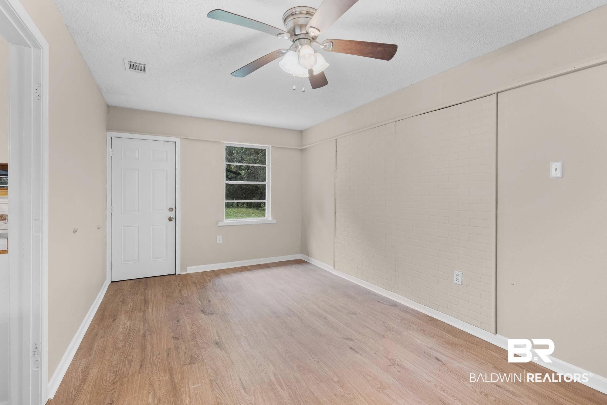 1560 Military Road Mount Vernon, AL 36560 - Photo 14 of 26 Spacious interior room featuring wood-finish flooring, neutral wall tones, and a ceiling fan with integrated lighting