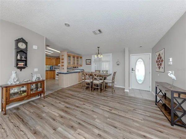 a living room with furniture a dining table and wooden floor