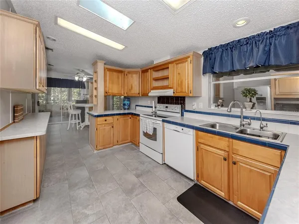 a kitchen with stainless steel appliances granite countertop a sink a stove and cabinets