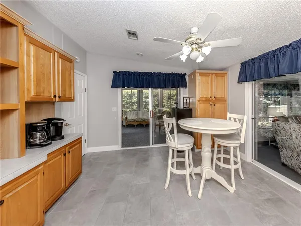 a kitchen with a dining table chairs stainless steel appliances and cabinets