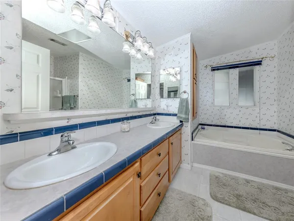 a bathroom with a granite countertop sink a large mirror and a bathtub