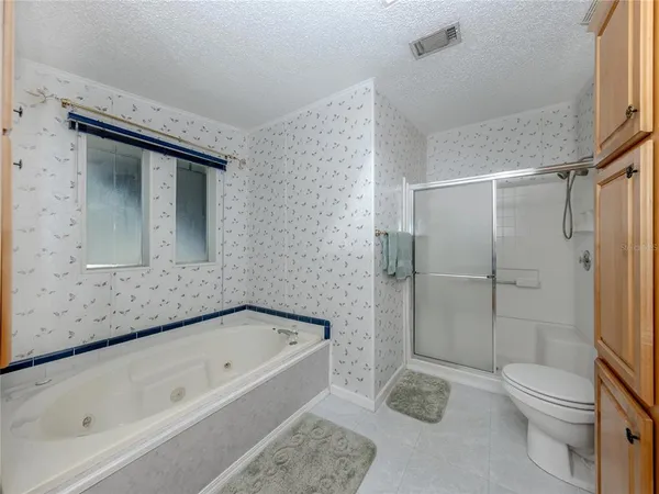 a bathroom with a granite countertop bathtub shower sink vanity and toilet