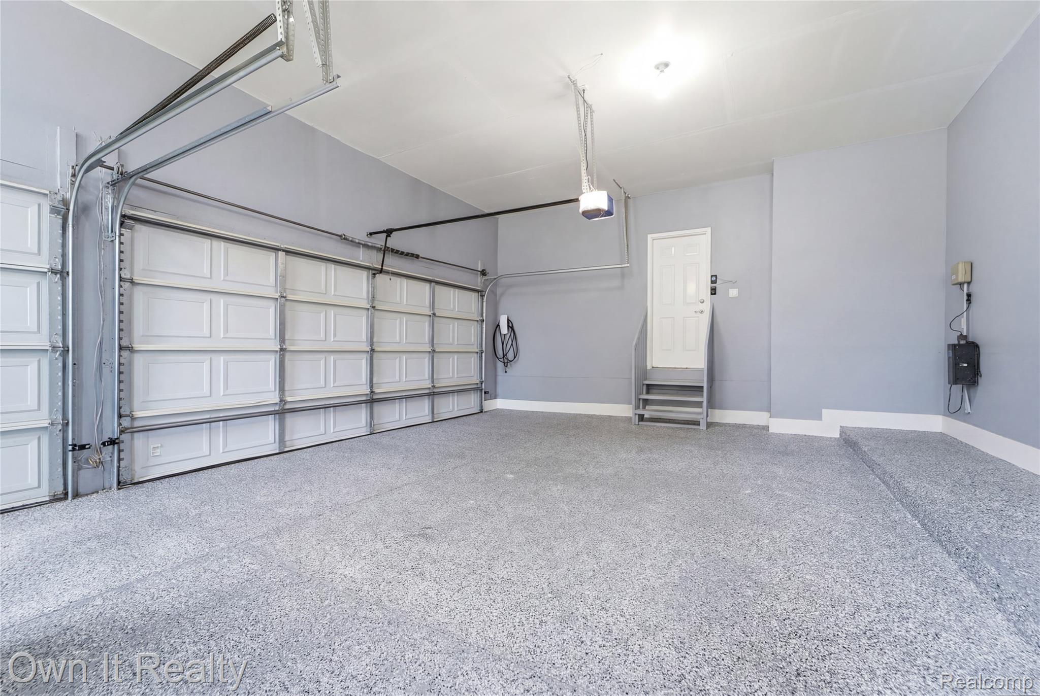 48280 Gladstone Road Canton, MI 48188 - Photo 49 of 59 Spacious garage with light grey walls and a speckled epoxy floor coating