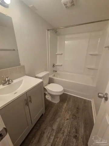 a bathroom with a sink a toilet and a large mirror