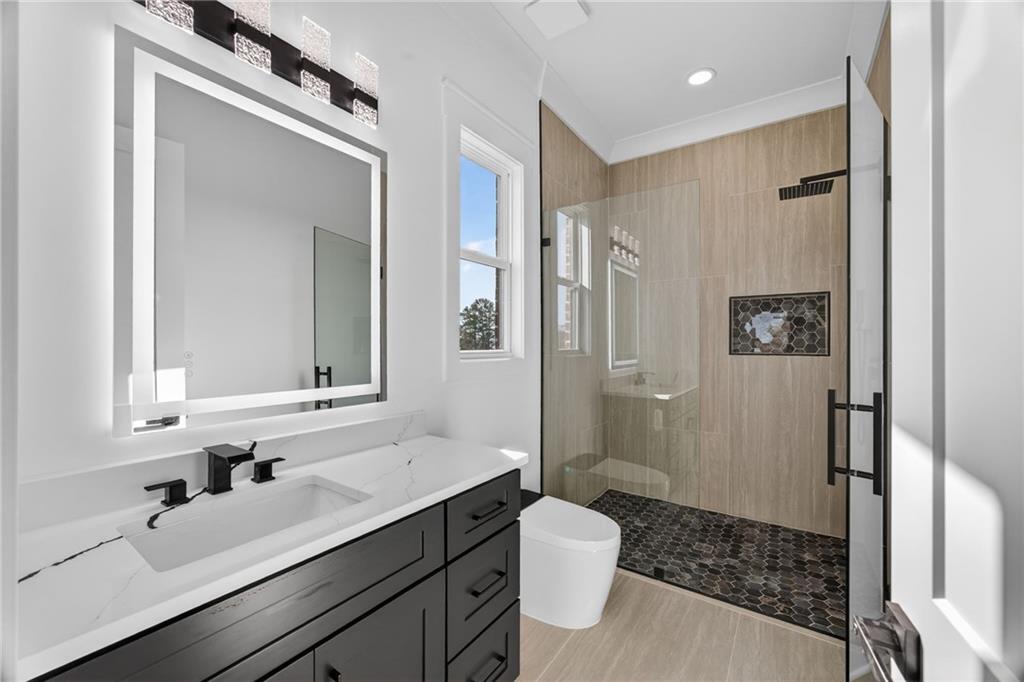405 Thunder Road Buford, GA 30518 - Photo 82 of 104 a bathroom with a sink a toilet a mirror and shower