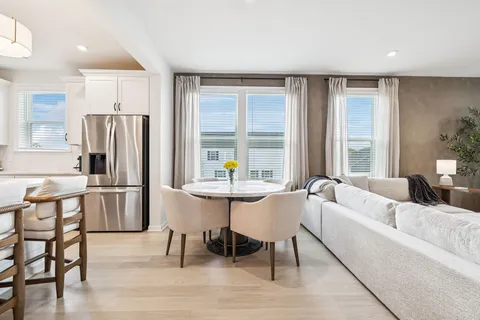 a living room with furniture and a refrigerator