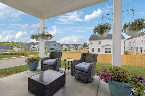 a living room with patio furniture and a potted plant