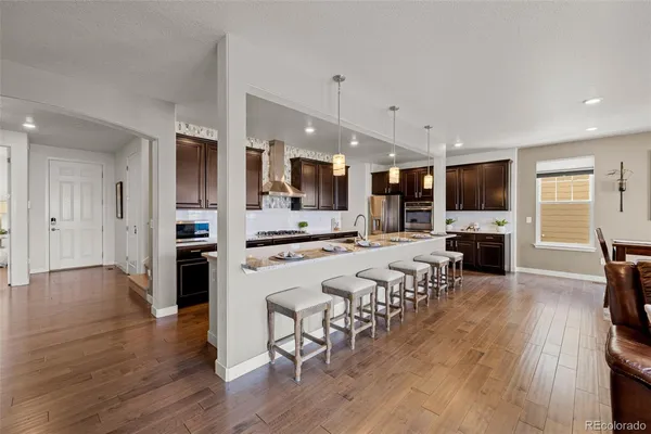 a large white kitchen with lots of counter space a sink appliances and cabinets