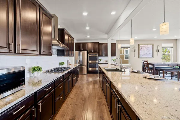 a large kitchen with stainless steel appliances granite countertop plenty wooden cabinets counter space a sink and a center island
