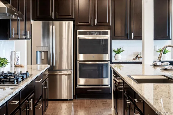 a kitchen with granite countertop a refrigerator stove and sink